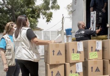 UN staff help unload humanitarian aid supplies to help in the response.