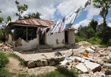Una casa dañada por el terremoto con las paredes desmoronadas.