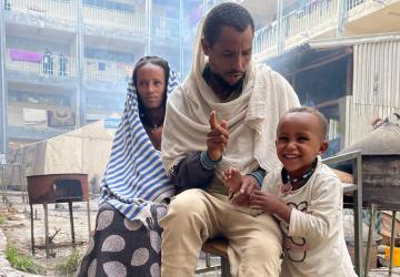 Una familia de Samre, en el suroeste de Tigray, se sienta junto a un gran complejo de apartamentos.