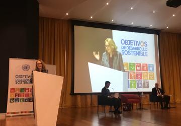 Allegra Baiocchi, United Nations Resident Coordinator in Costa Rica, standing at a podium in front of a microphone during an event.