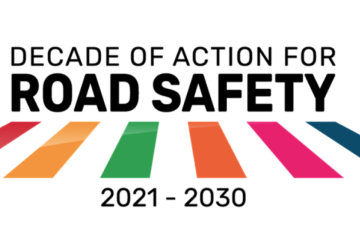 A logo with the text "Decade of Action for Road Safety" along with the colours of the SDGs marked as lines on a zebra crossing.