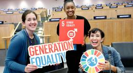 شابات يحملن لافتات أهداف التنمية المستدامة وجيل المساواة.