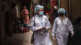 Dos trabajadores de desarrollo miran su lista de verificación durante una campaña de sensibilización en Dhaka en el marco del proyecto LIUPC del PNUD en Bangladesh.