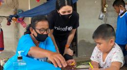 تتحدث المتطوعة في اليونيسف، راسا باتيكاسيمكول (في الوسط)، إلى صبي صغير في لقاء نادر وجهًا لوجه خلال الإغلاق الذي تسببت به جائحة كوفيد-19.