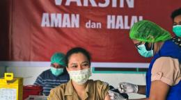 تتلقى فريدة سيافي، عاملة صحية تبلغ من العمر 42 عامًا، تتلقى لقاح كوفيد-19 في مركز صحي محلي في إندونيسيا.