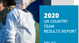 A child in a face mask and white shirt faces the camera