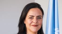 Portrait de Karima El Korri, la nouvelle Coordonnatrice résidente des Nations Unies en Malaisie, au Brunéi Darussalam et à Singapour, avec le drapeau des Nations Unies en arrière-plan.