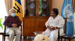 رئيسة وزراء بربادوس والأمين العام للأمم المتحدة يجلسان على كرسيين وخلفهما علمي الأمم المتحدة وبربادوس.