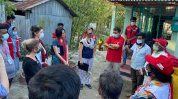 La Coordonnatrice résidente Mia Seppo s'entretient avec un groupe de personnes composé de femmes et d'hommes se tenant debout, en cercle, à l'extérieur d'un bâtiment. Toutes les personnes présentes portent un masque de protection respiratoire. 