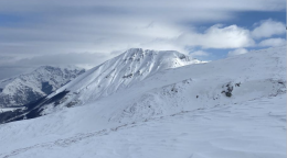 An image of a snowy mountaintop on a cloudy day.