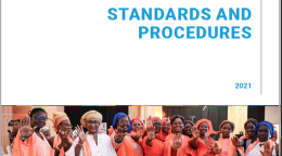 Women wearing orange stand together and proudly show their palms as a symbol to stop. 