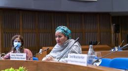 Una mujer habla por el micrófono en una reunión.