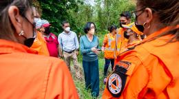 Un grupo de personas formando un círculo en un área verde.