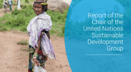 A girl looking back as she walks across an open field.