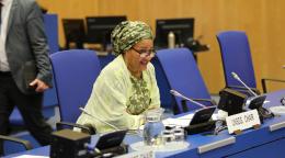 Una mujer con un chal amarillo en una silla azul habla por un micrófono en una reunión de la ONU.