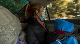 Roza Nurymova, de 36 años, y dos de sus pequeños viajan en taxi tras visitar la oficina de Sana Sezim.