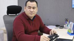 Man sitting at an office desk with a Braille device
