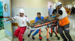 A group of healthcare workers carry a stretcher with someone injured