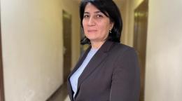 Фотография женщины, Нигоры Шоматовой, в пиджаке на фоне коридора