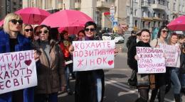 Женщины стоят с плакатами на улице