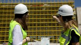 Two women in an outdoor setting looking at an infrastructure project