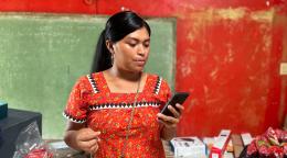 Mujer con vestido rojo mirando su teléfono.