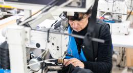 A woman uses a sewing machine while at work.