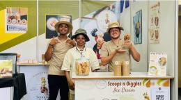 A group of people in front of kiosk selling icecream