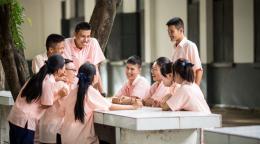 A group of young women and men sitting together and laughing