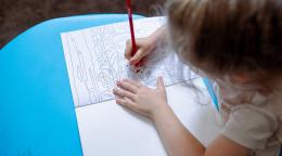 A young Moldovan child is colouring.