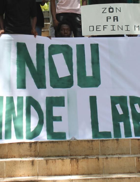 A banner held up by youth activists reads, 'we demand peace'.
