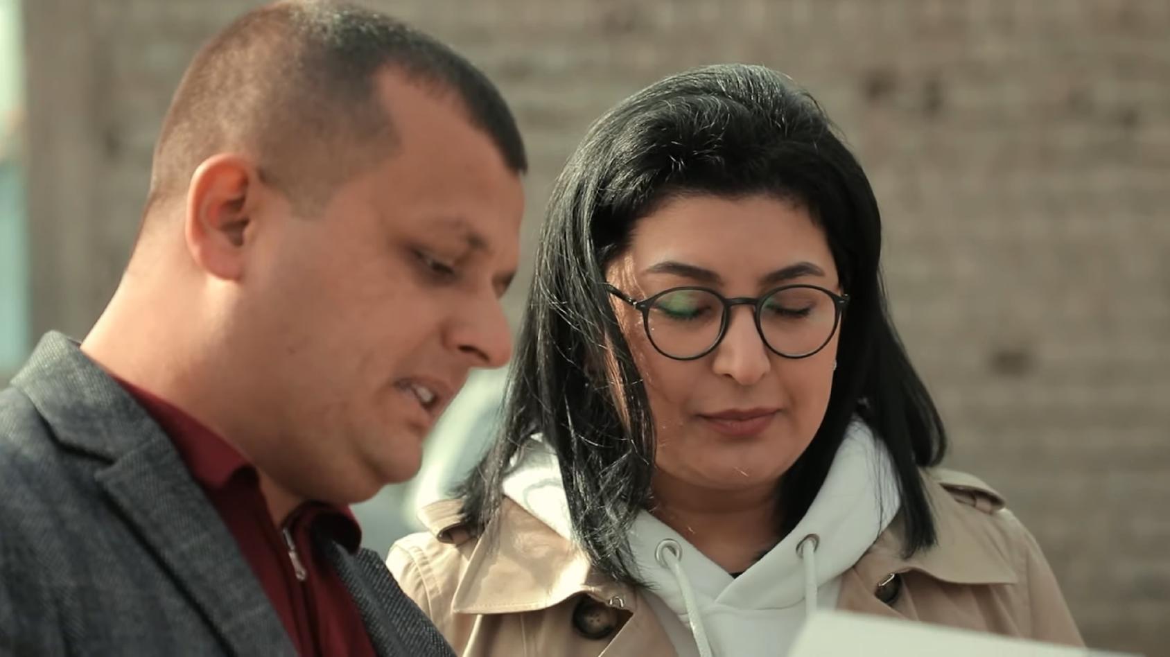 一名男子在集会上与阿基达-莫基罗娃分享文件中的信息。