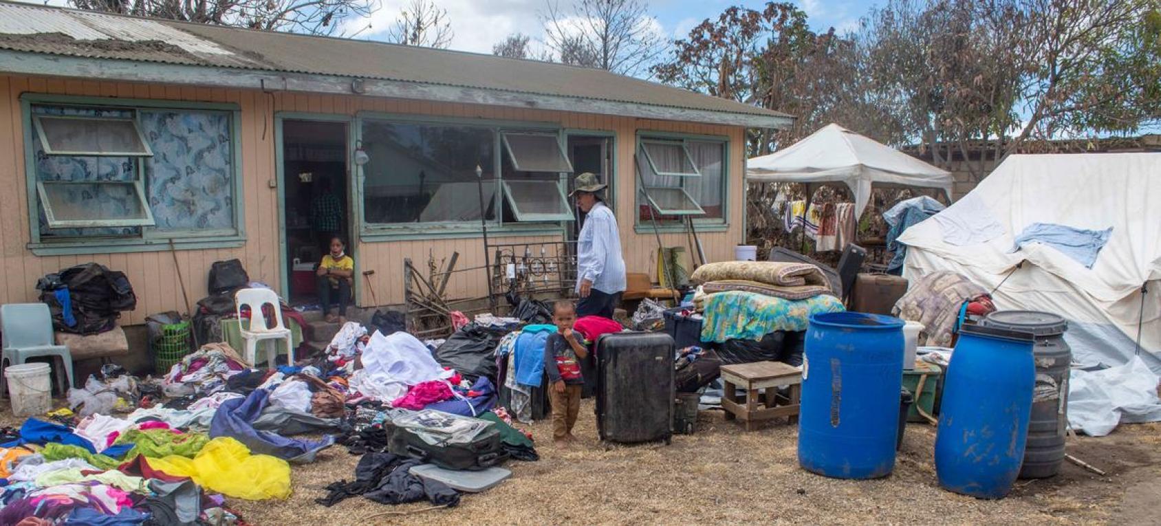 Two people air drying their belongings outside of a house. 