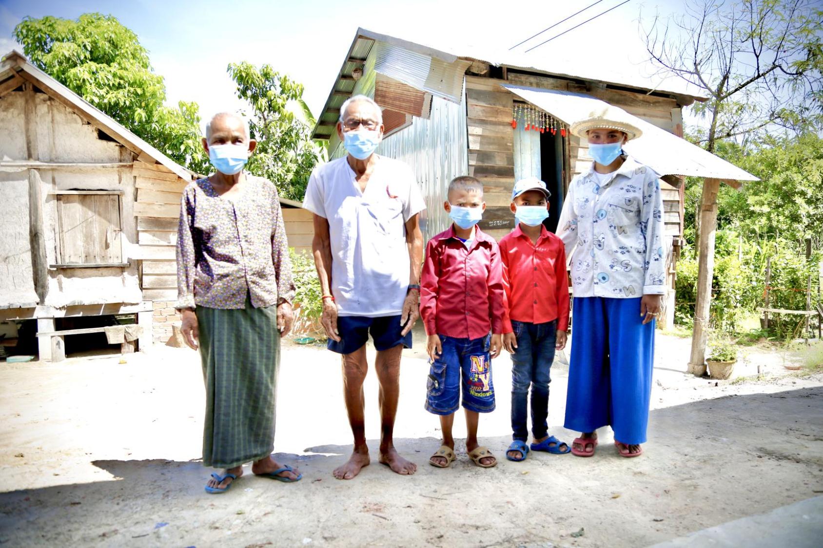 Una familia de cinco personas de pie, una al lado de la otra.
