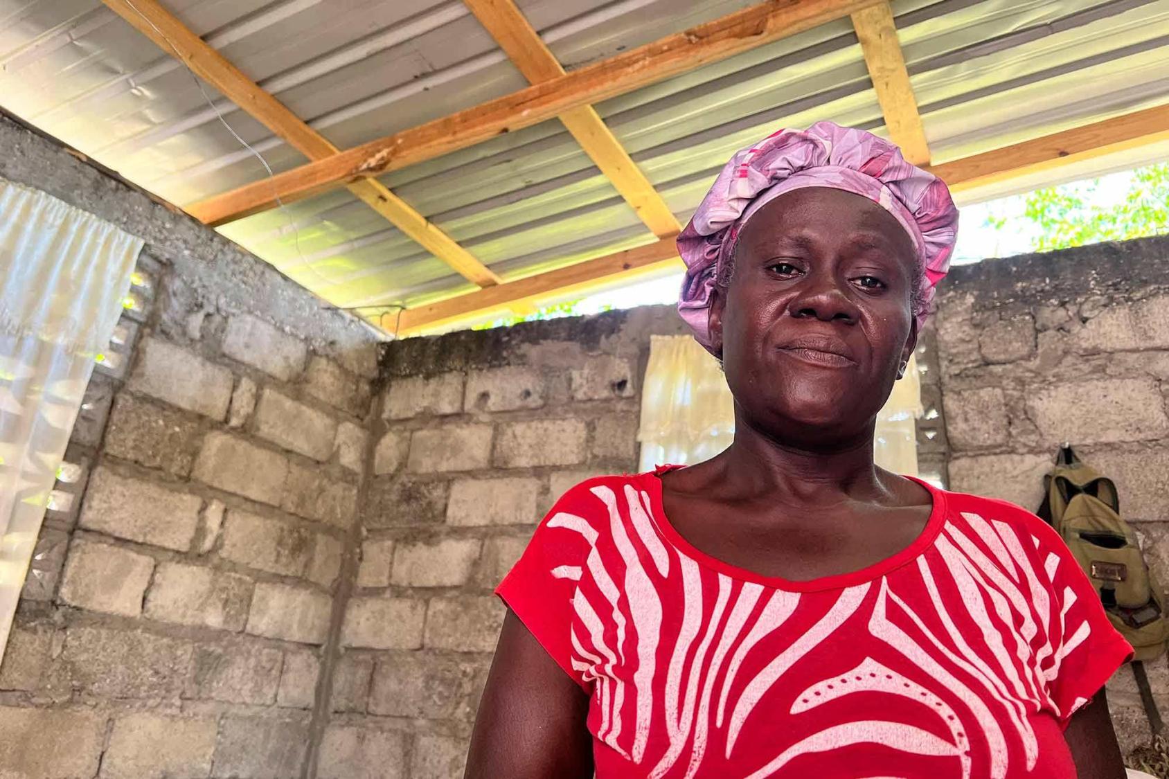 صورة لامرأة تقف في غرفة محمية بسقف من الصفيح.