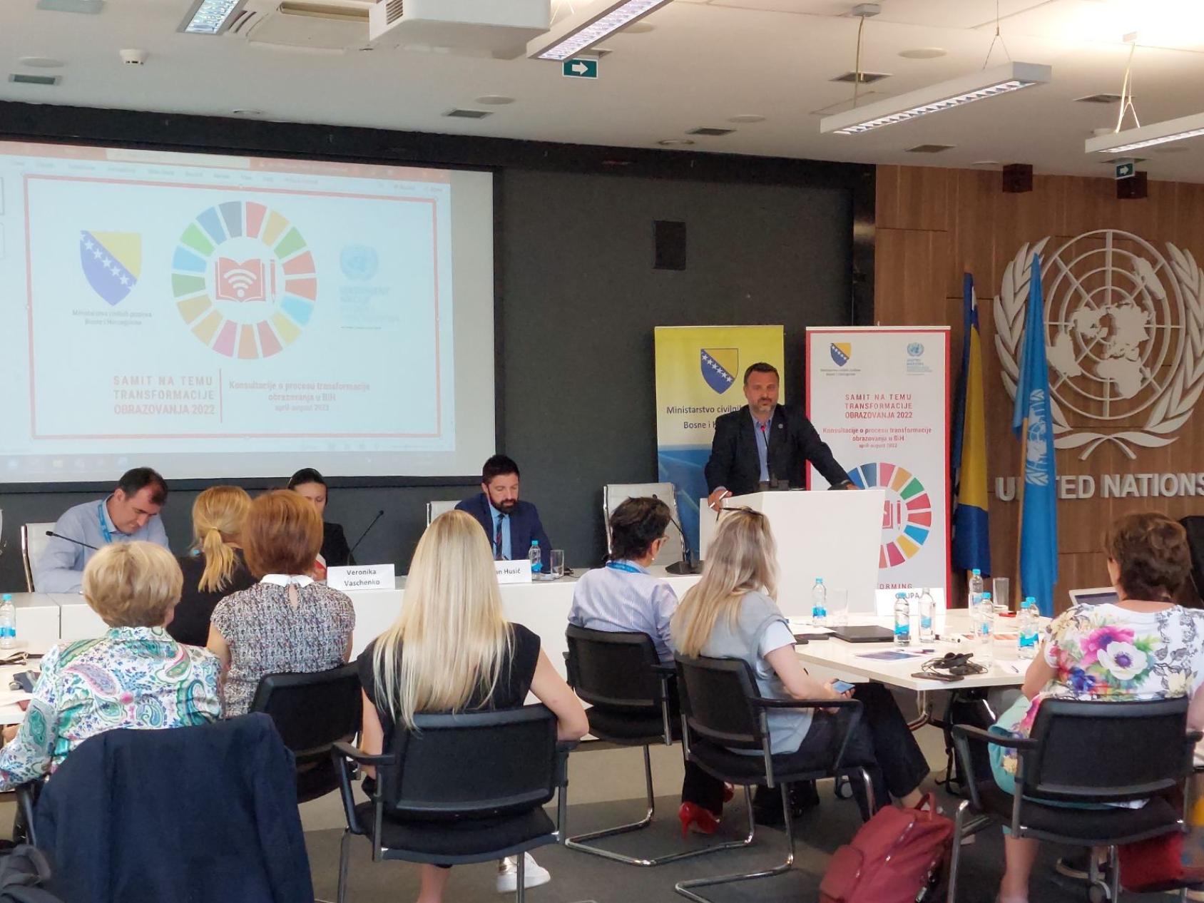 一名男子在一群人面前介绍情况。