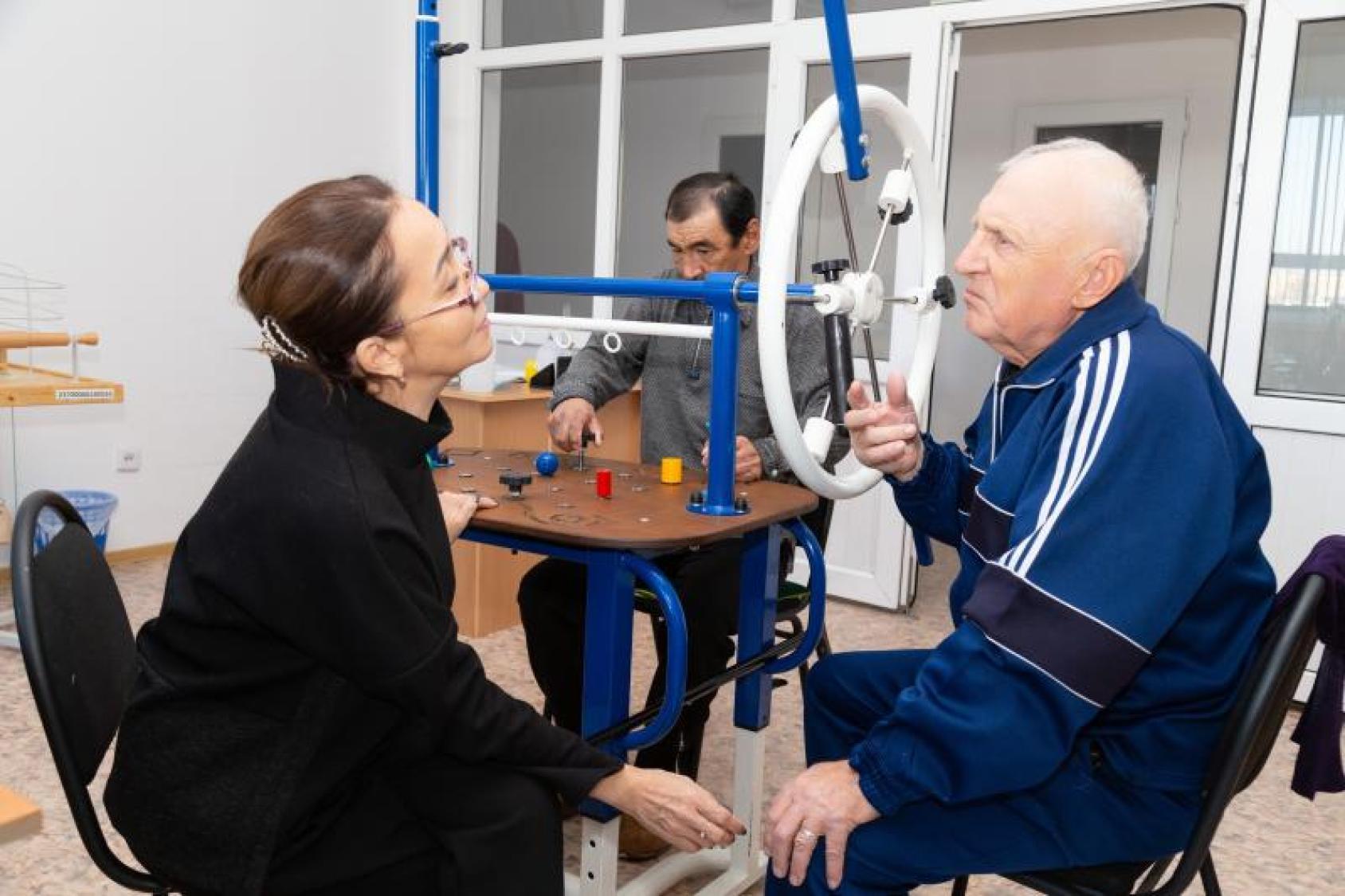 Woman in a black shirt talking to a man in a blue shirt in a gymnasium