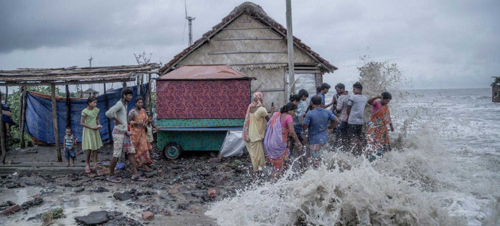 Floods crashing against a house and people