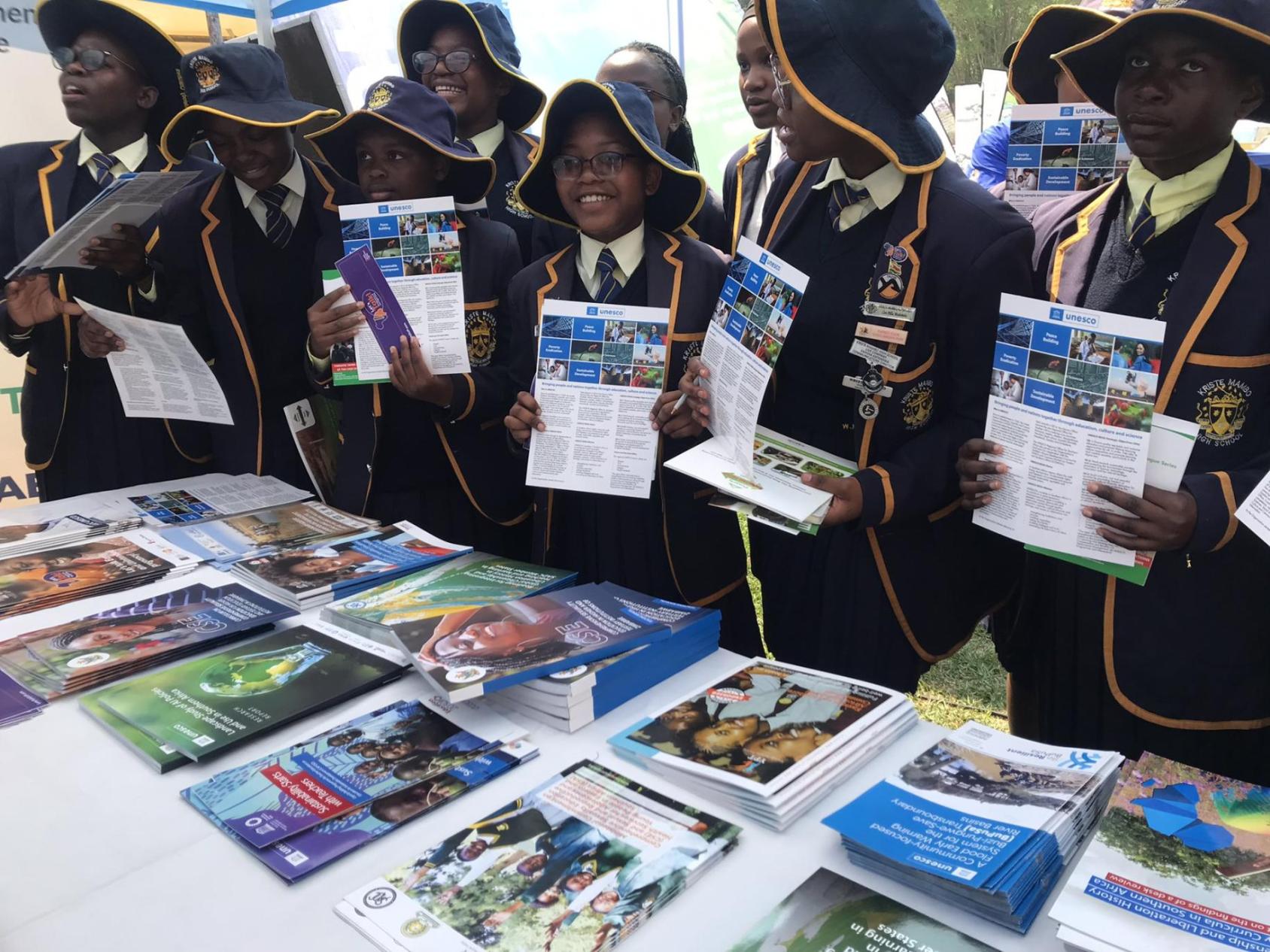 A group of children in Zimbabwe hold up posters