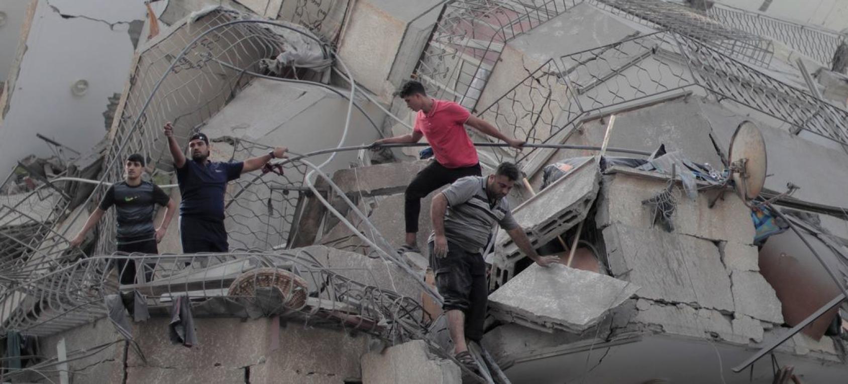 Un grupo de hombres trepa por un edificio destruido en Gaza.