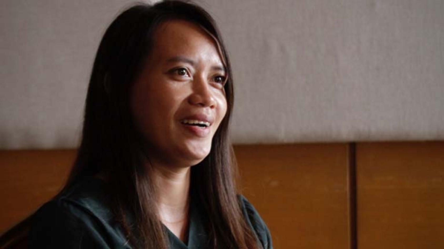 A close up shot of a woman in a black shirt and straight brown hair
