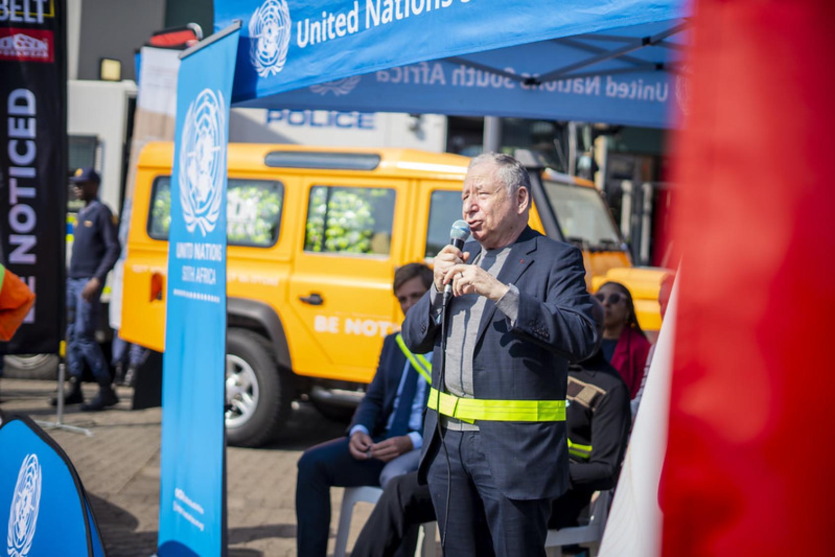 A man stands in an outdoor tent addressing an audience