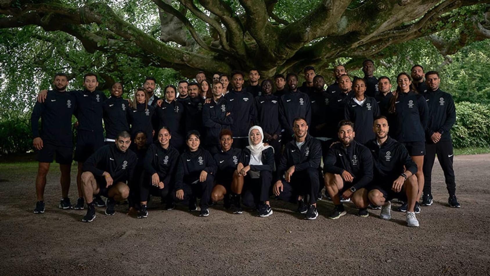 A group of sportspersons in black uniforms under a tree