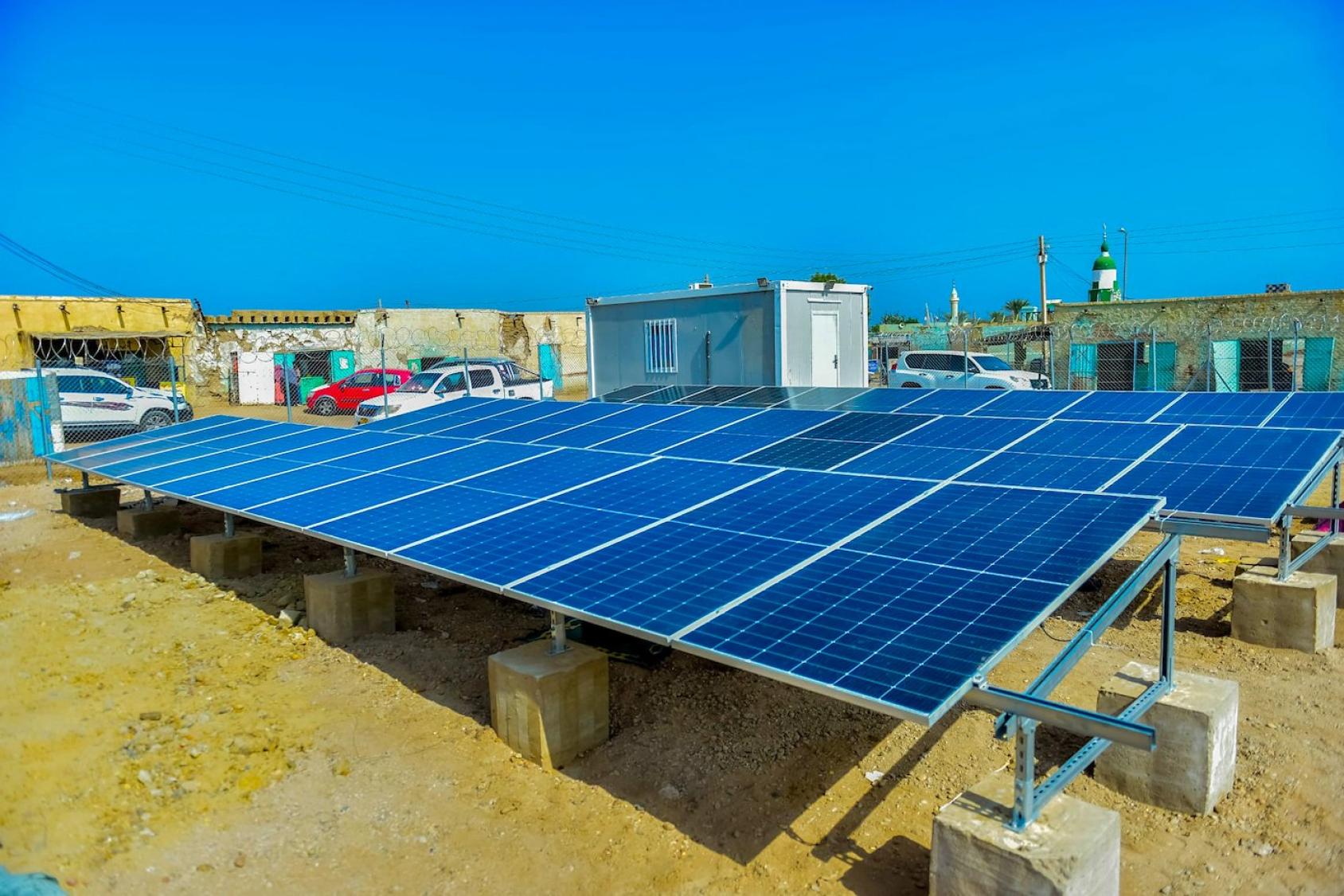 Three giant blue solar panels propped up on concrete reinforcements in Sudan
