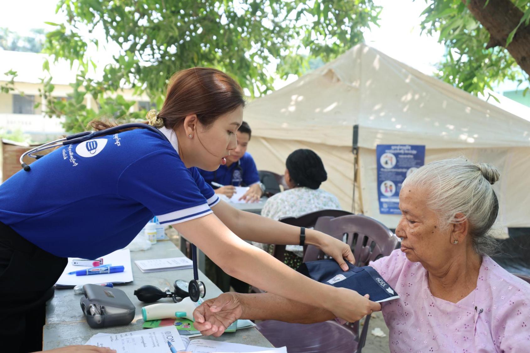  IOM nurse monitors the blood pressure of an elderly woman in Amarapura Township, Mandalay
