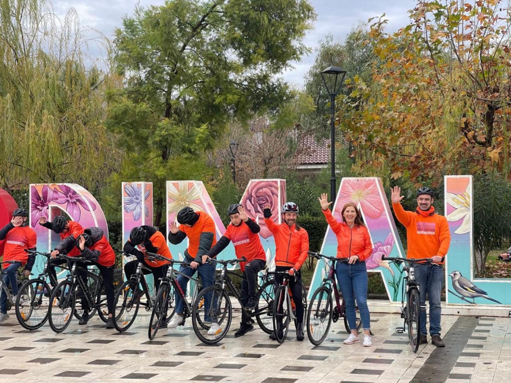 Группа велосипедистов на фоне арт-объекта I LOVE DIMAL