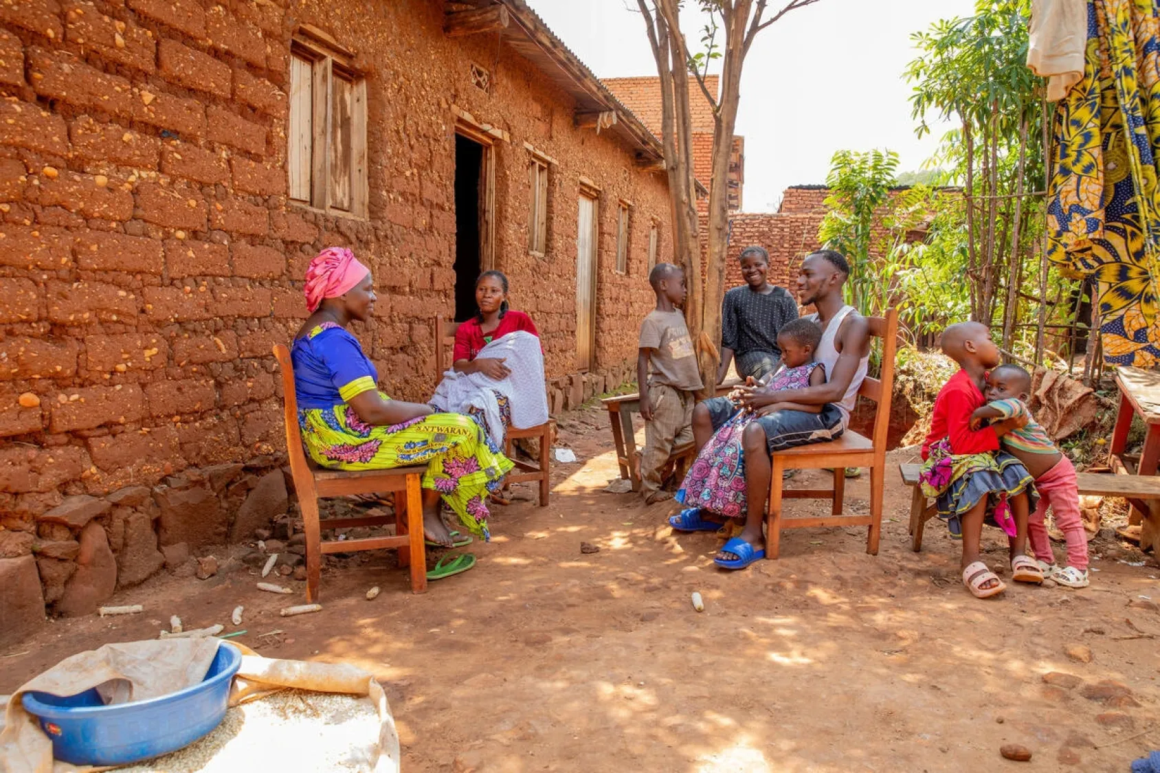 Chancelline, son mari Ishara et leurs enfants sont assis devant la maison de Charlotte, leur hôte burundaise, à Rugombo, dans la province de Cibitoke, au Burundi.