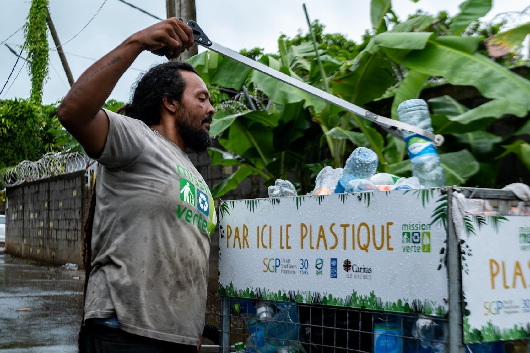 Man throwing plastic bottles in a bin