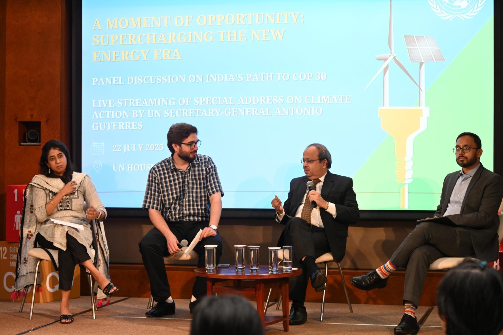 Four people on a stage with a backdrop behind them
