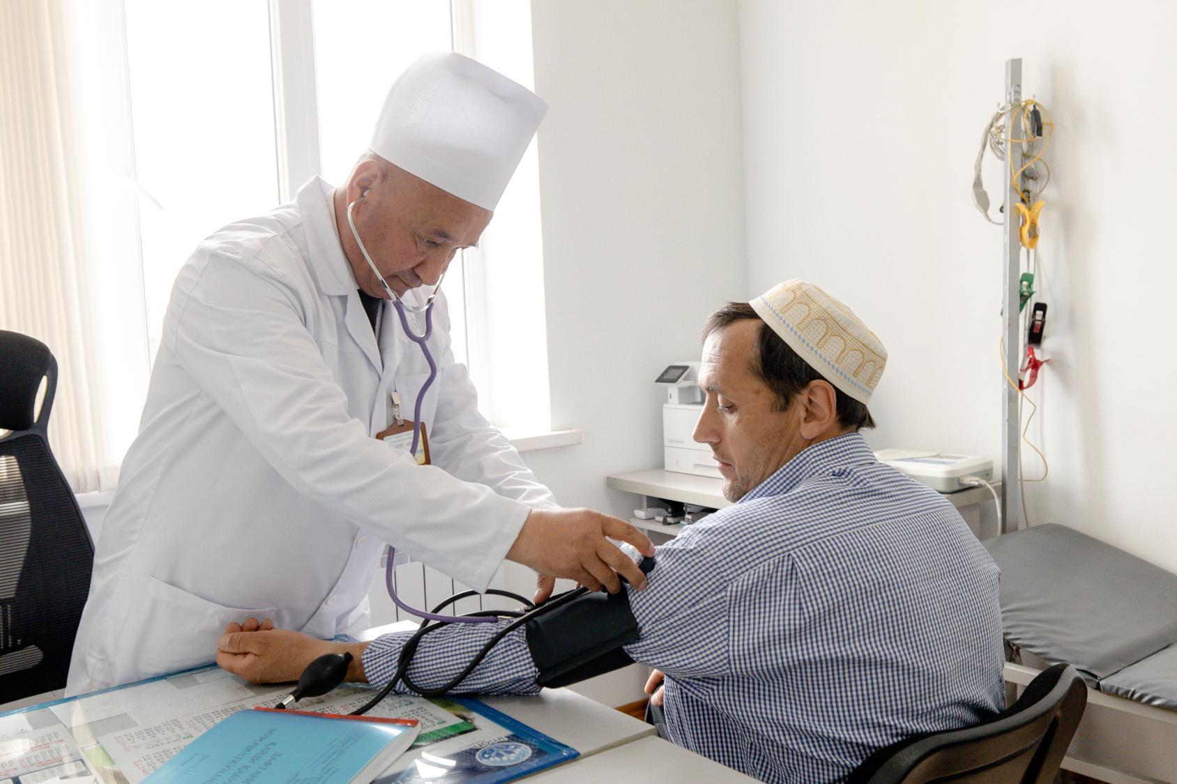 a man is being checked by a doctor in an indoor room 
